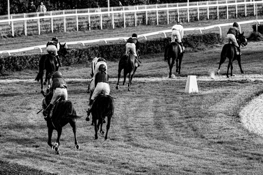 Black and white photo of horse racing at a track in Wrocław, Poland.