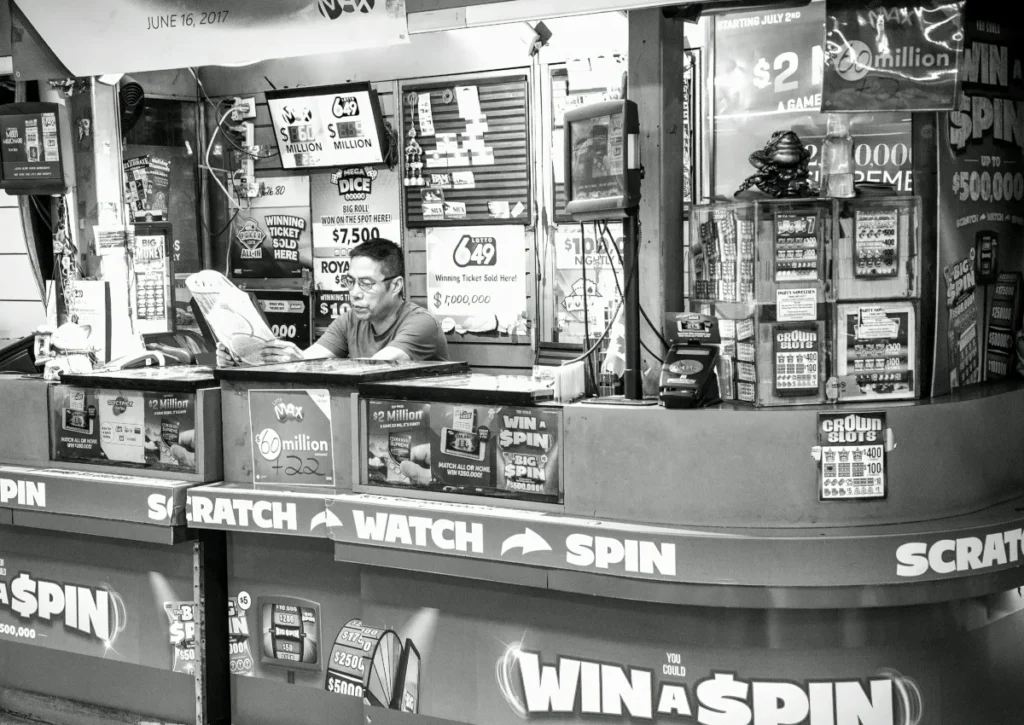 A man reads at a busy lottery ticket booth filled with signs and advertisements.