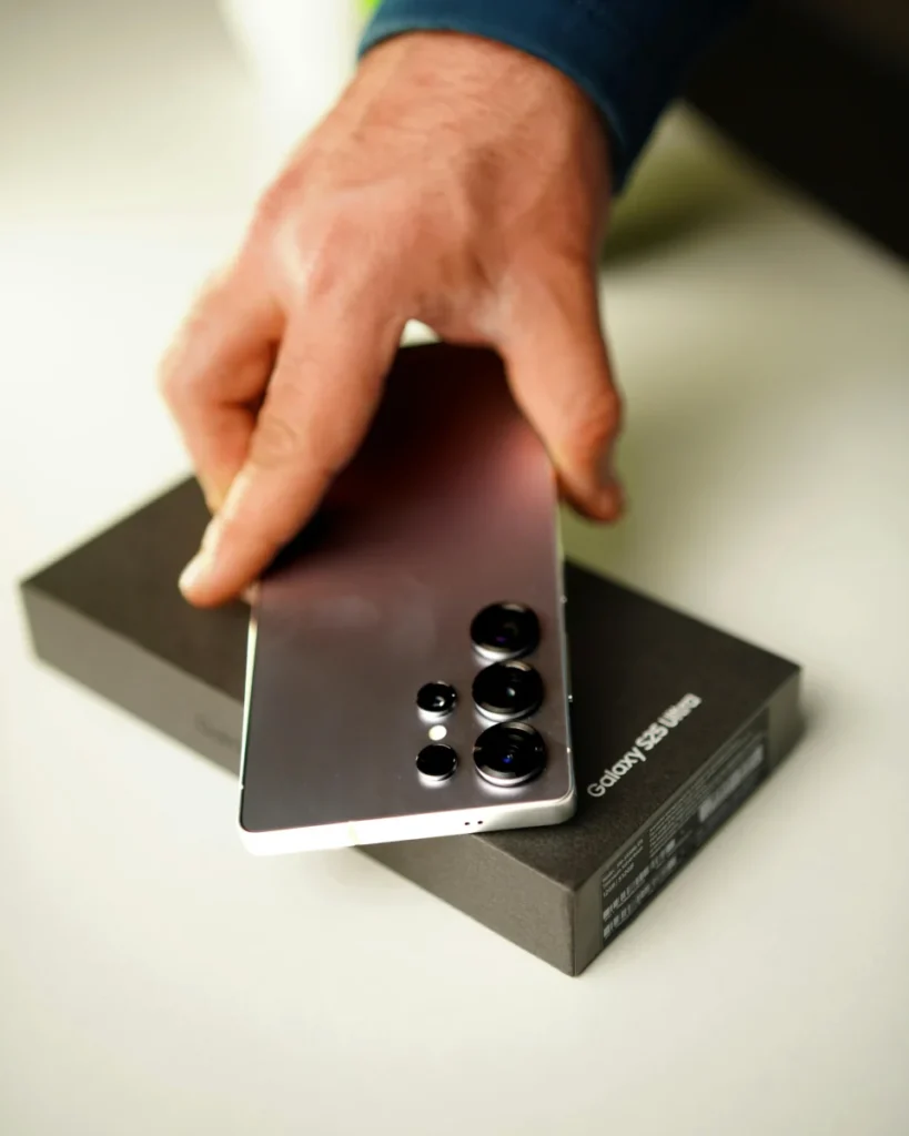 Samsung liquéfie les stocks du Galaxy S25 Ultra avant lancement : jusqu’à -48% sur des palettes entières ! Close-up of hand holding Samsung Galaxy S25 Ultra smartphone with box.