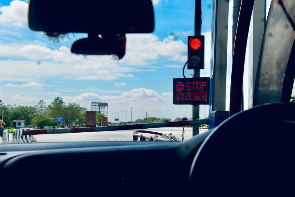 Car interior view at a toll booth in Suryapet, India with a stoplight.