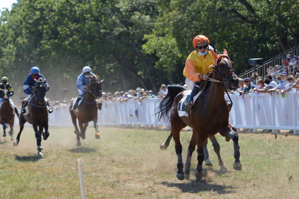 Résultats Quinté Mercredi Caen – Arrivée et Rapports PMU 10 Juin 2026 Exciting horse race capturing jockeys in action with a cheering crowd under sunny skies.