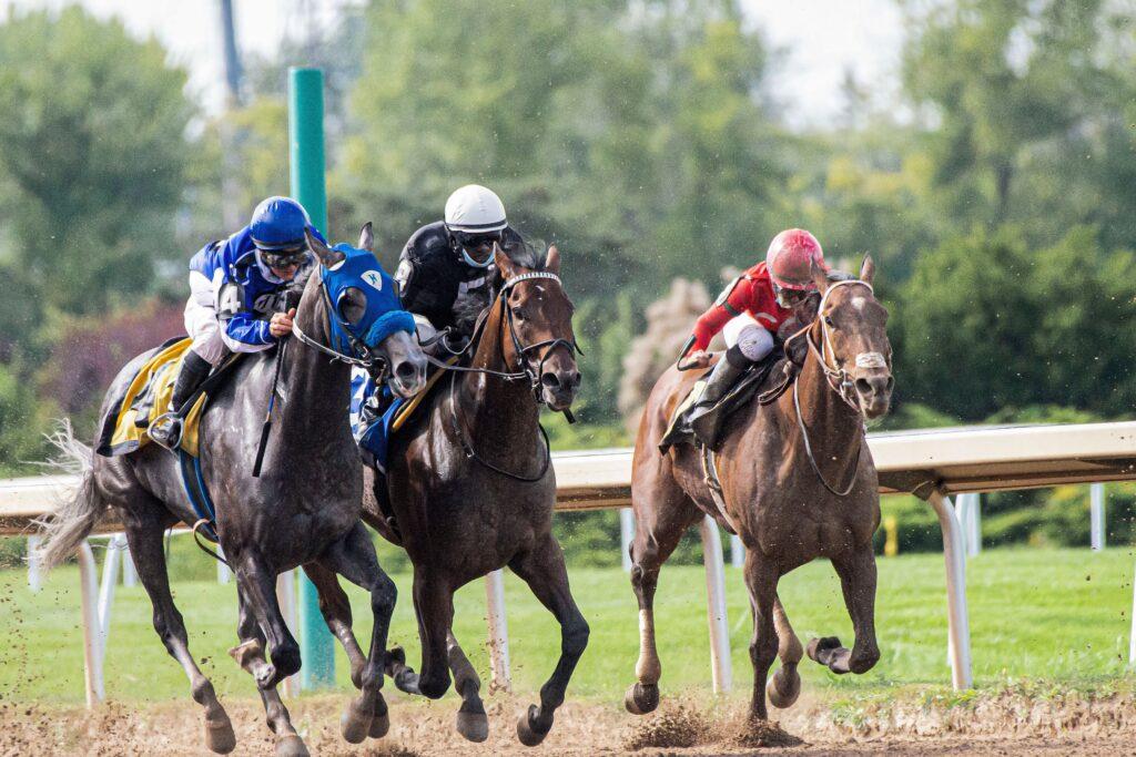 Quinté Chantilly – Pronostic et Partants 14 Juin 2026 Dynamic capture of a thrilling horse race showcasing three jockeys and racehorses in intense competition.
