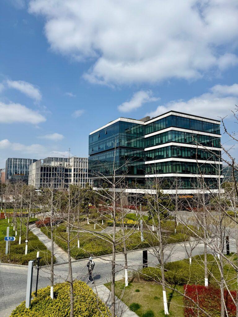 Microsoft incite ses commerciaux a critiquer OpenAI Contemporary office buildings surrounded by a landscaped urban park under a clear blue sky.