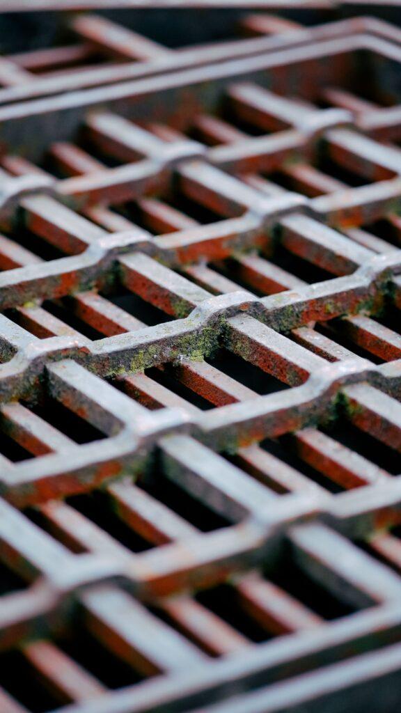 Detailed view of a rusty metal grate displaying texture and pattern